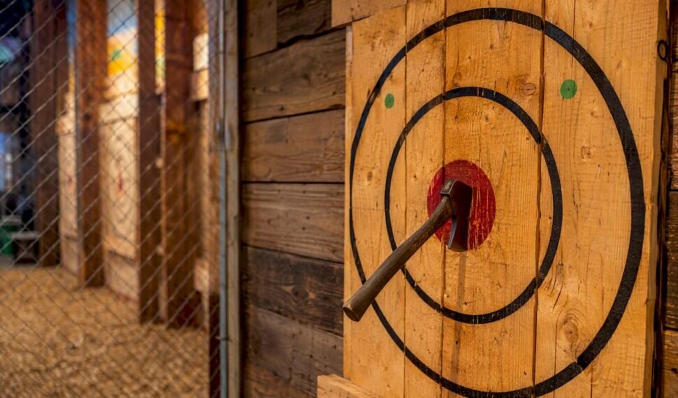 Axe stuck in bullseye on wooden target