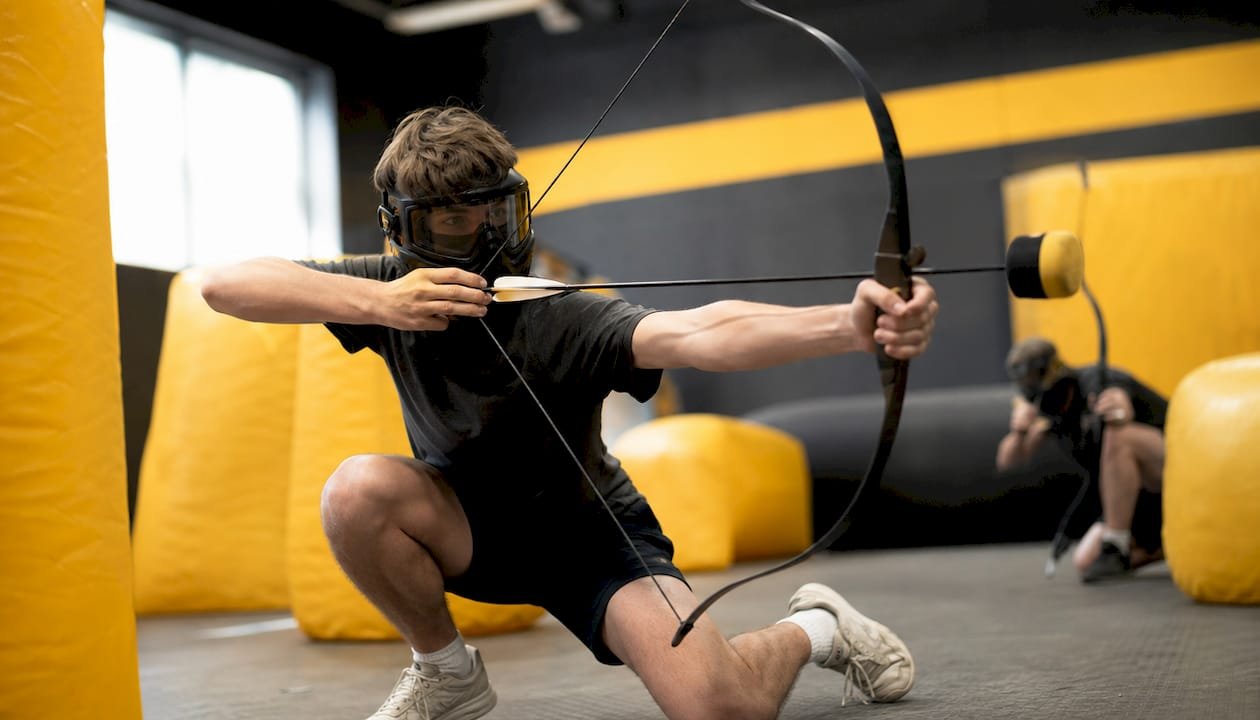 Teens playing combat archery indoors