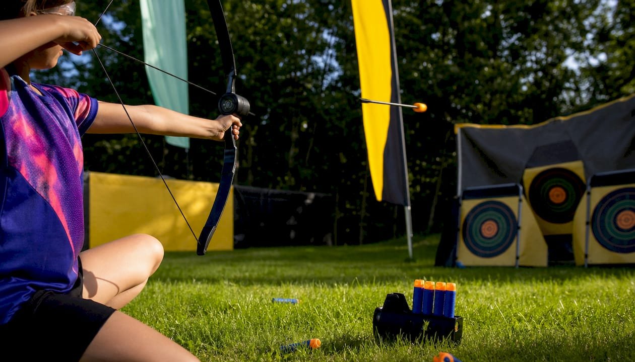 Child aiming foam bow in combat archery game