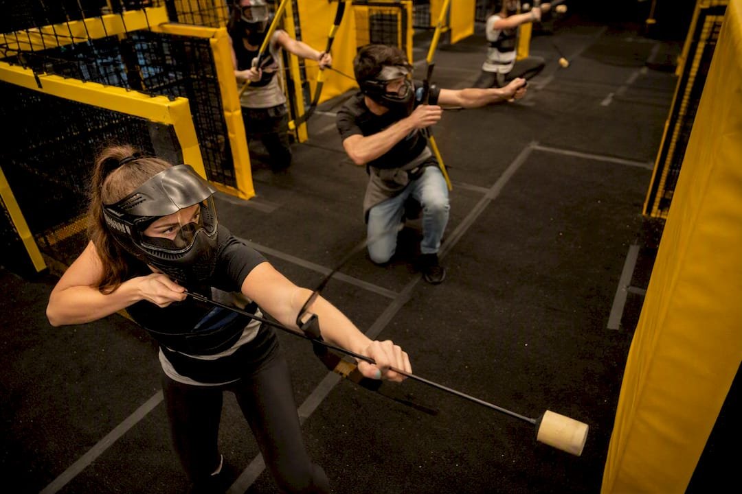 Players mid-action in indoor archery tag