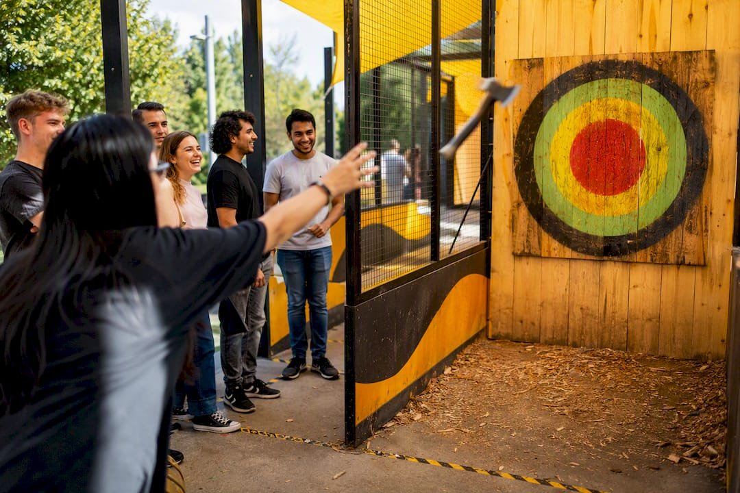Player throwing axe at dartboard style target