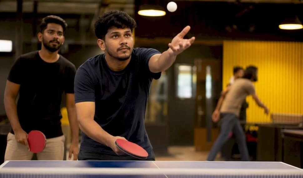 Table tennis player serving in doubles match