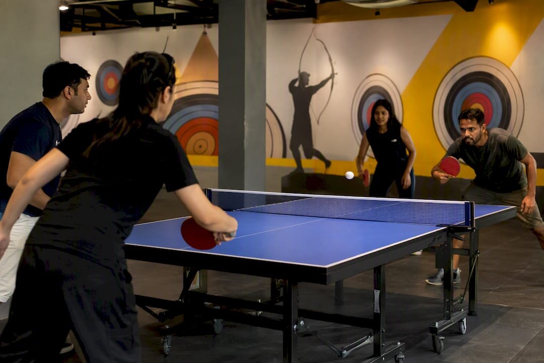 Doubles players alternating hits in table tennis rally