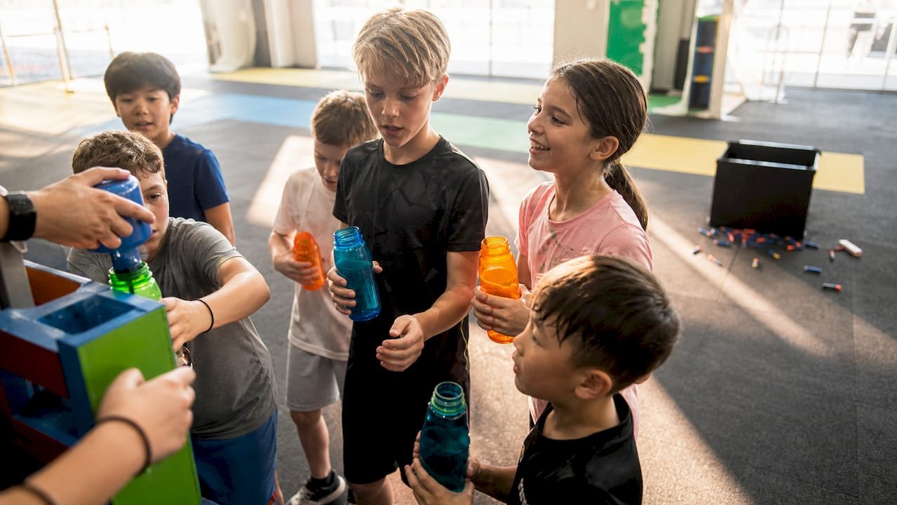 Kids refilling water bottles during nerf party break