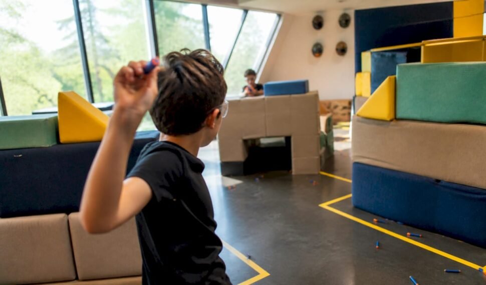 Child throwing foam dart in indoor nerf arena