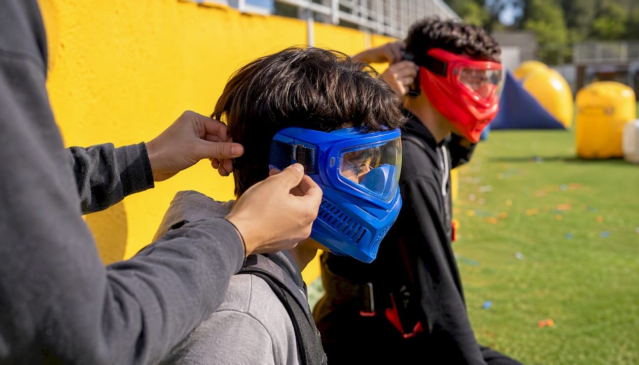 Hands fitting safety goggles before game