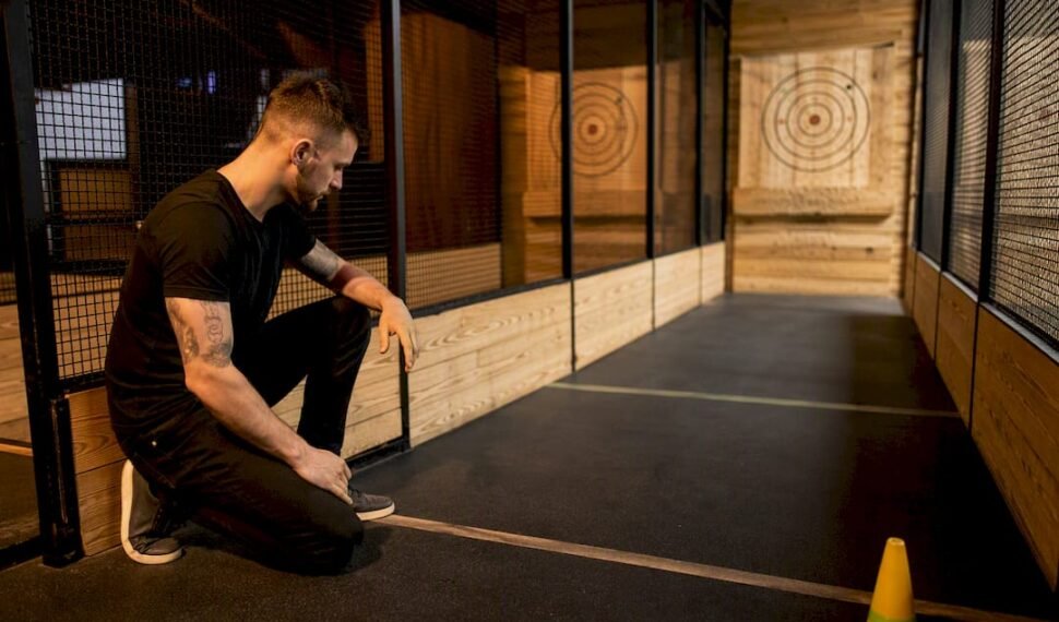 Staff inspecting a controlled axe throwing lane