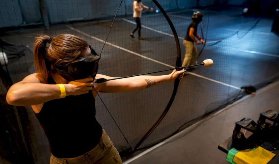 Adults playing combat archery at a birthday party
