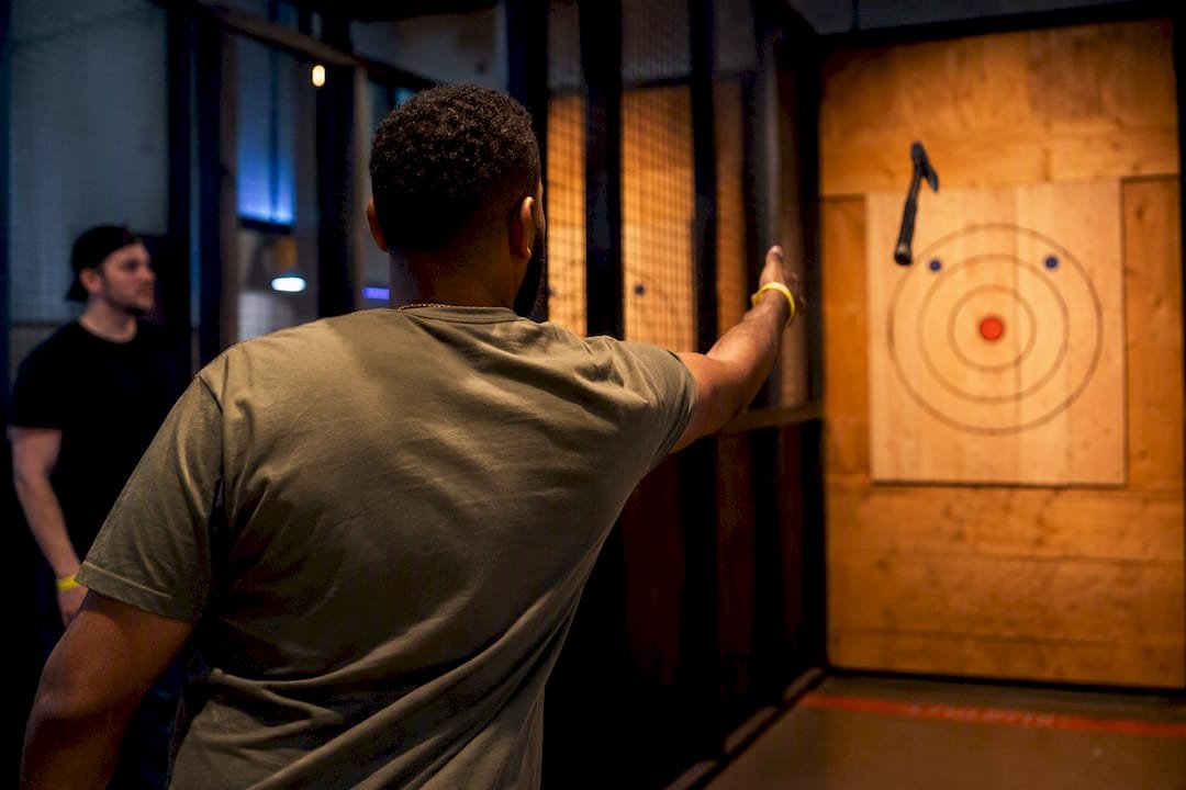 Adults trying supervised axe throwing at venue