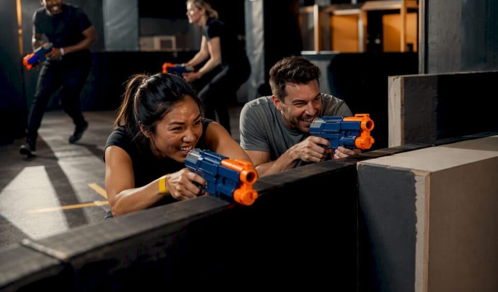 Coworkers playing an indoor Nerf battle
