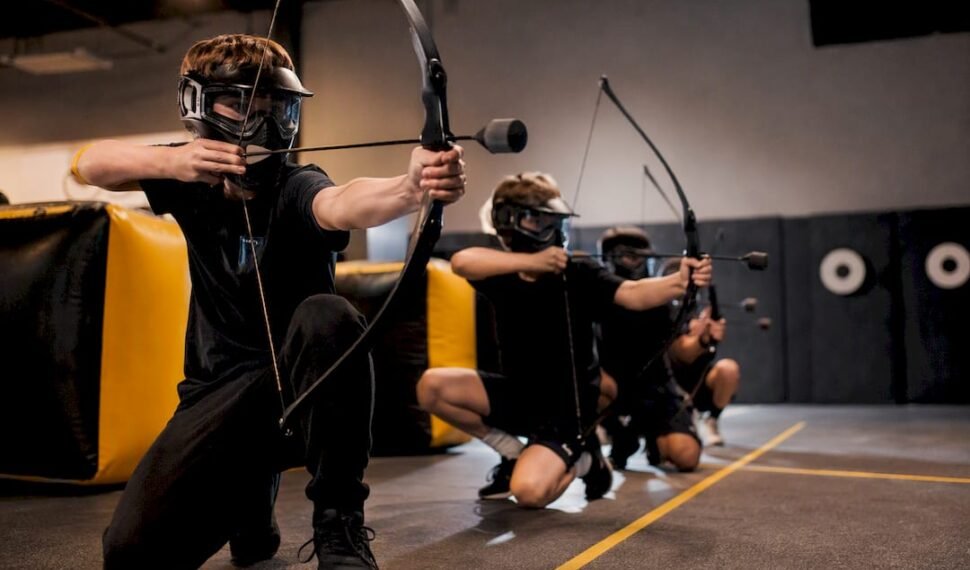 Birthday guests playing combat archery indoors