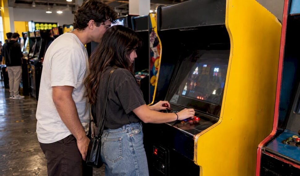 Friends playing a classic arcade cabinet