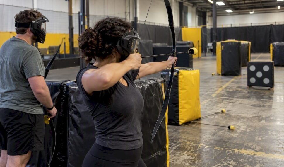 Couple playing combat archery indoors