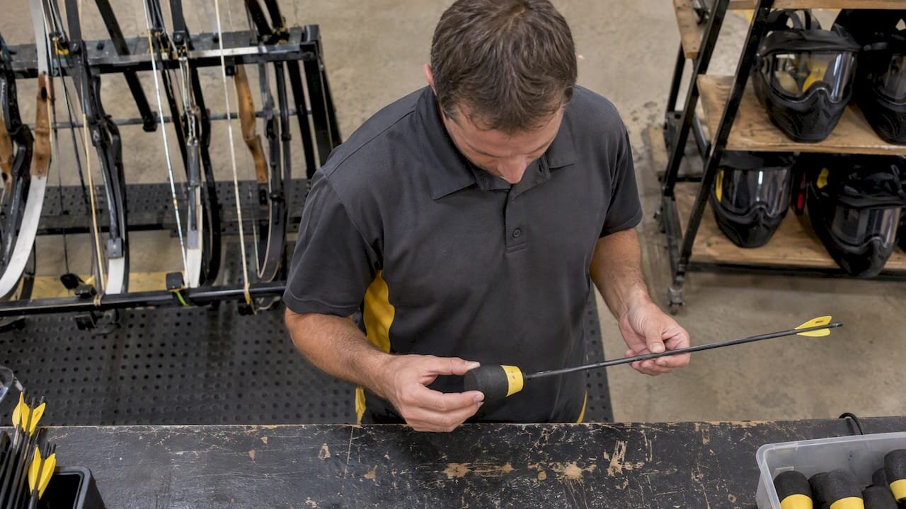 Staff member inspecting a foam-tipped arrow