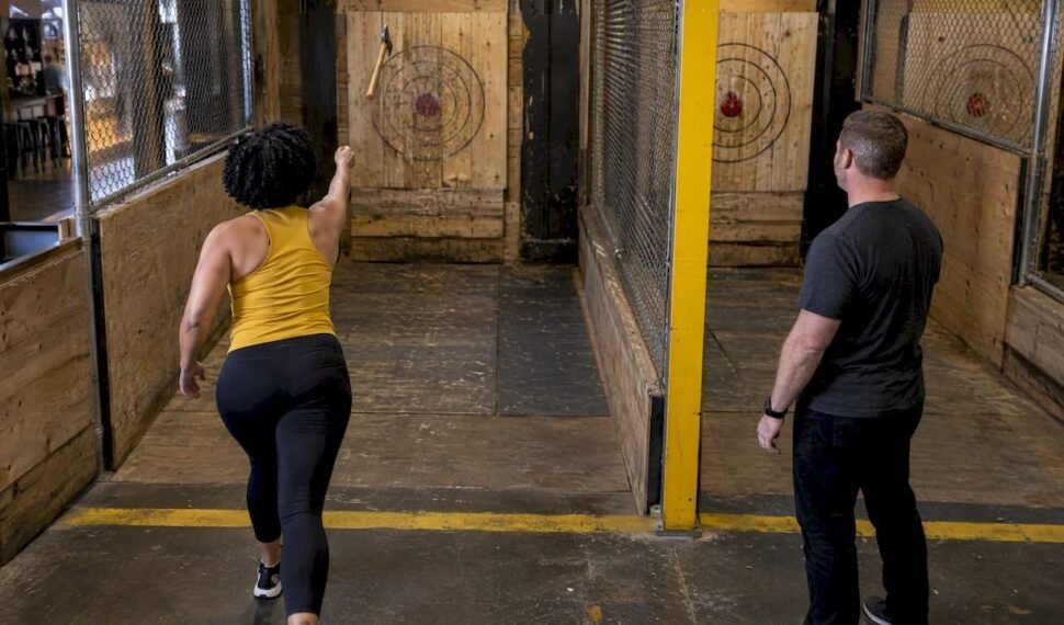 A league competitor throws as a judge watches