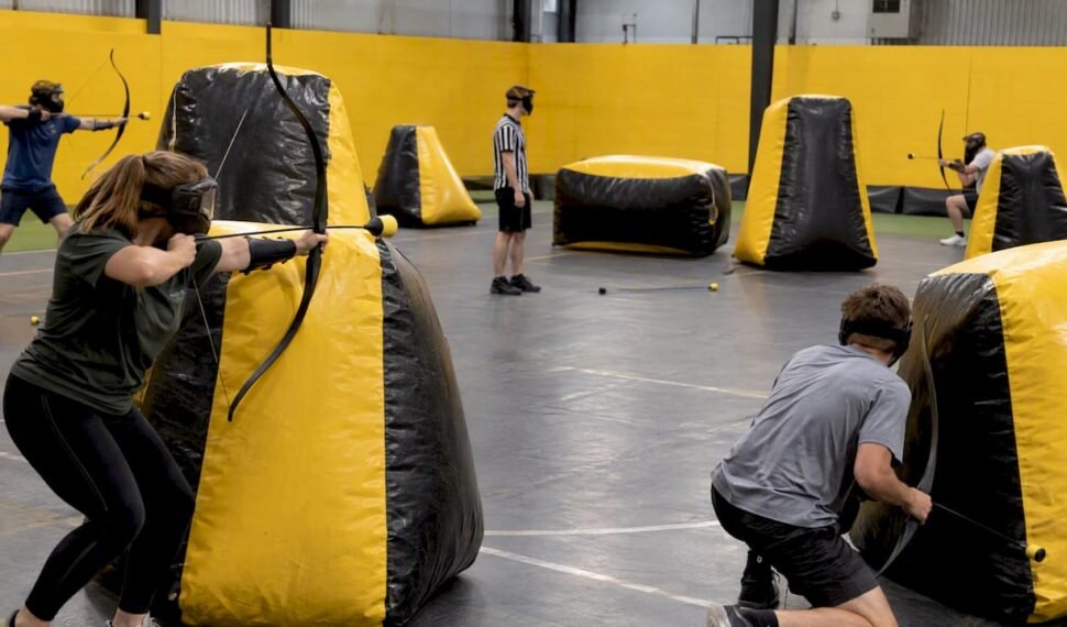 Masked players compete behind inflatable archery bunkers